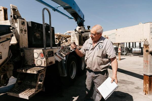 Buyer comparing prices and values of PTO-equipped and standard used semi trucks
