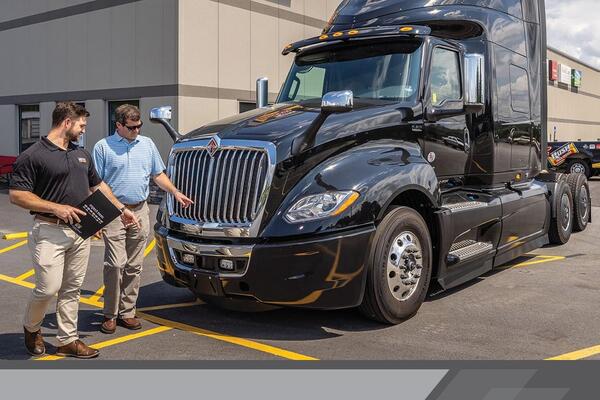 A well-maintained truck with complete service records can provide better value than a famous brand with poor maintenance history. Buyer comparing different commercial truck brands and inspecting engine, cabin, and mechanical condition at a Canadian dealership