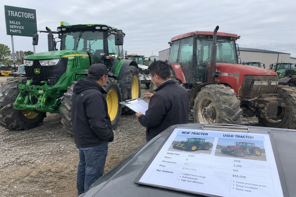 Agricultural equipment buyer comparing the purchase cost and long-term value of a new tractor versus a well-maintained used tractor